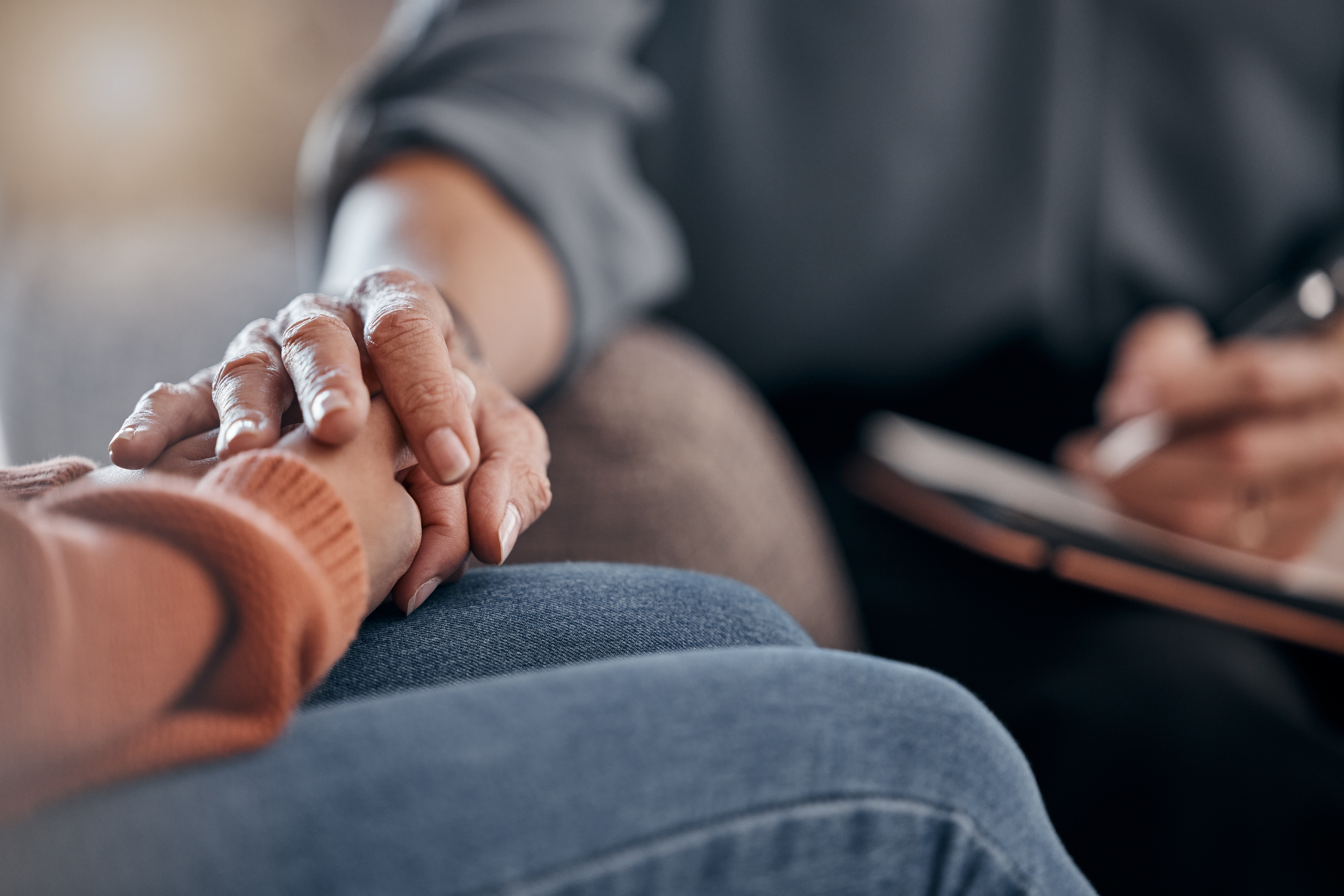 Two people holding hands for comfort during therapy